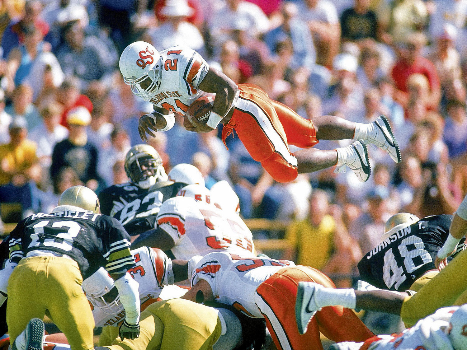 Heisman Trophy winner Barry Sanders flies over the defense of Colorado for a TD.