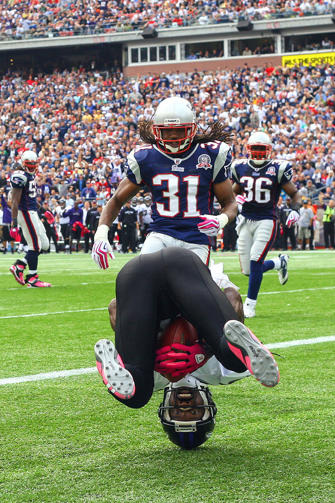 Standing on his head Baltimore receiver Derrick Mason holds on to make a catch .      