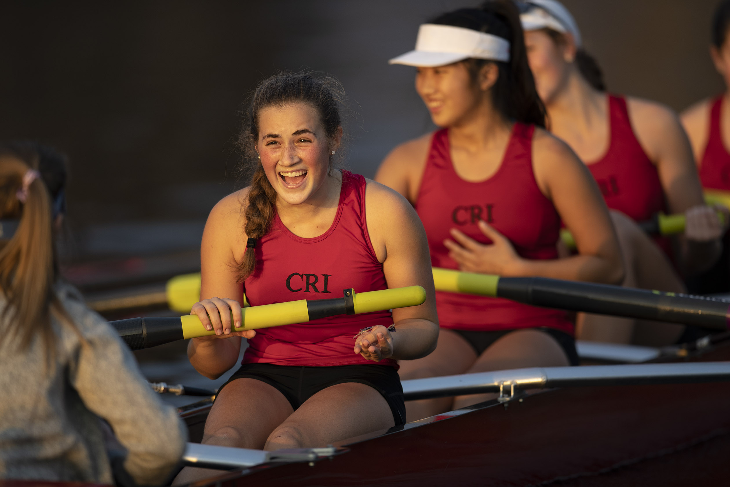Members of the varsity girls rowing team enjoy a laugh during a team practice. 