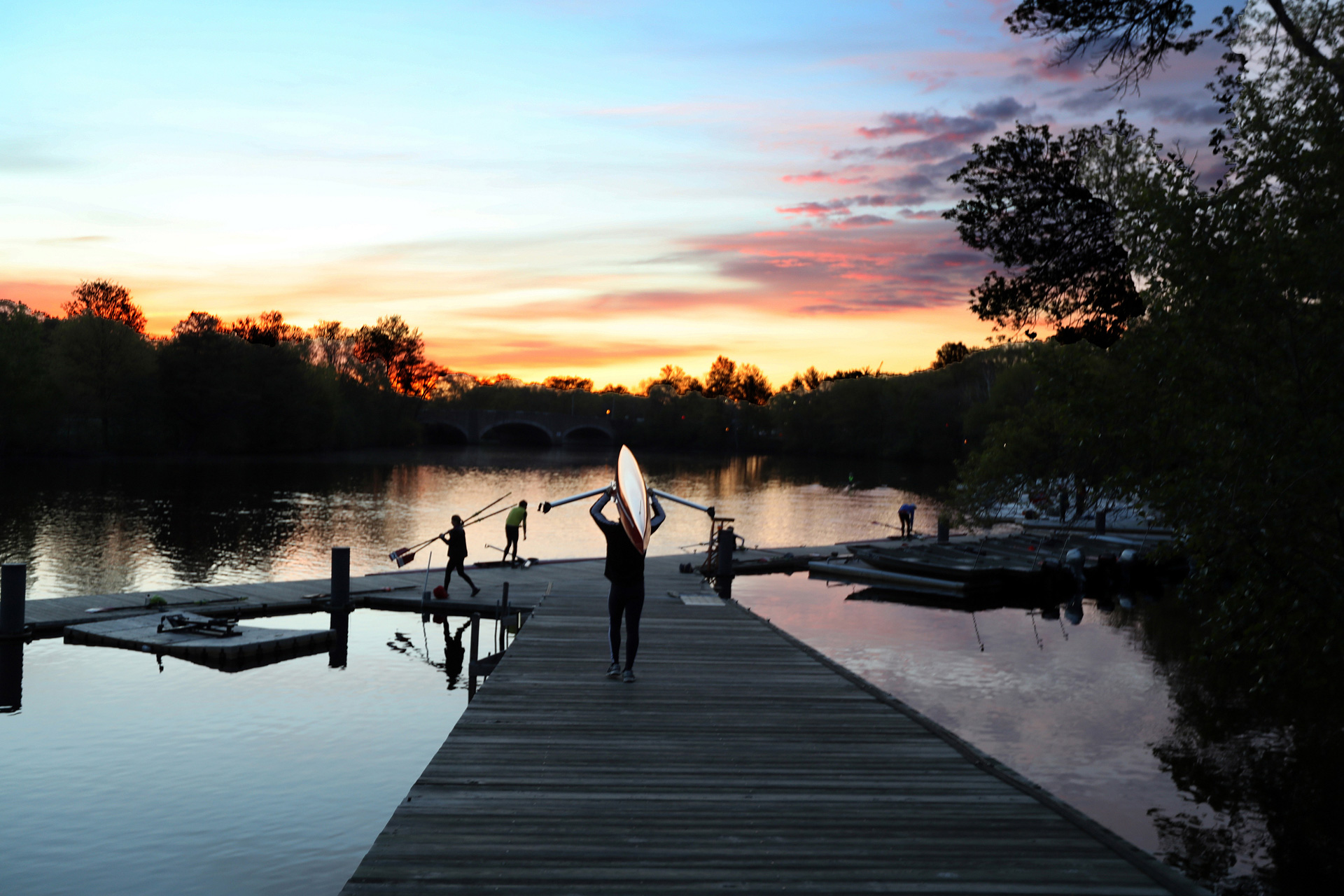 A rower heads down the dock for an early morning rowing session.