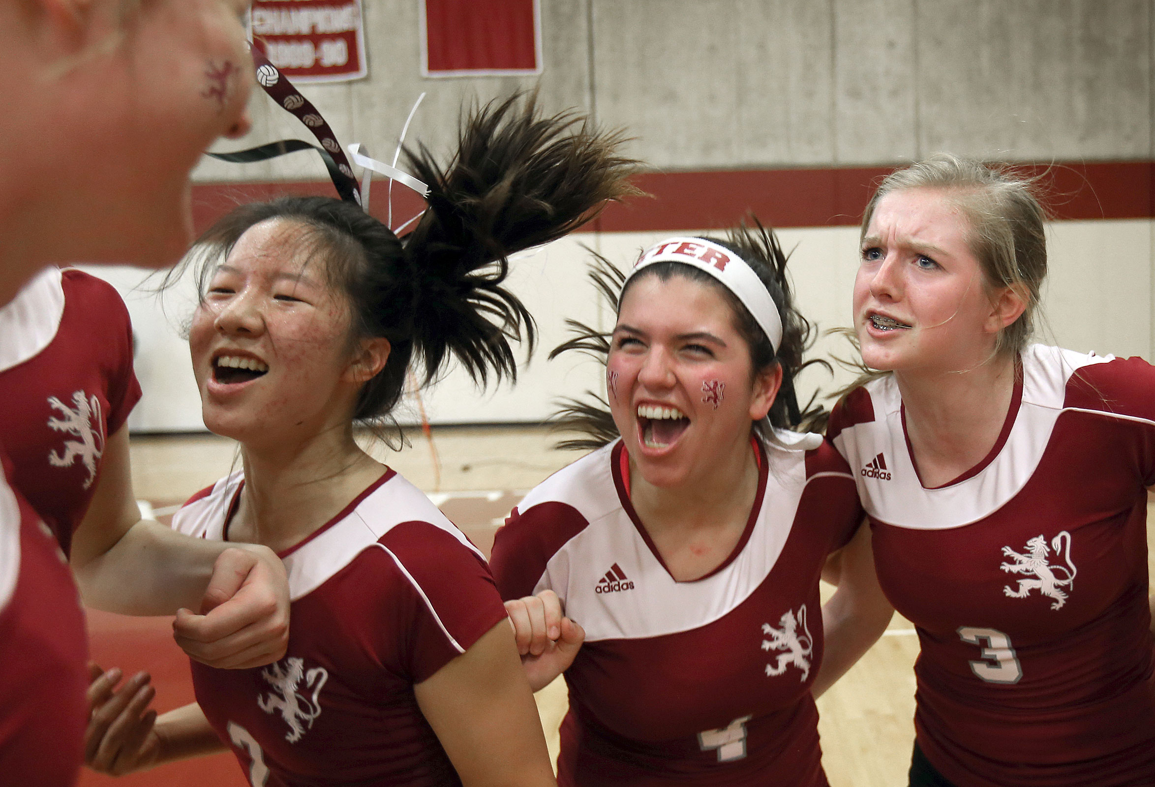 A group of Phillips Exeter volleyball players celebrate a win over Phillips Andover.