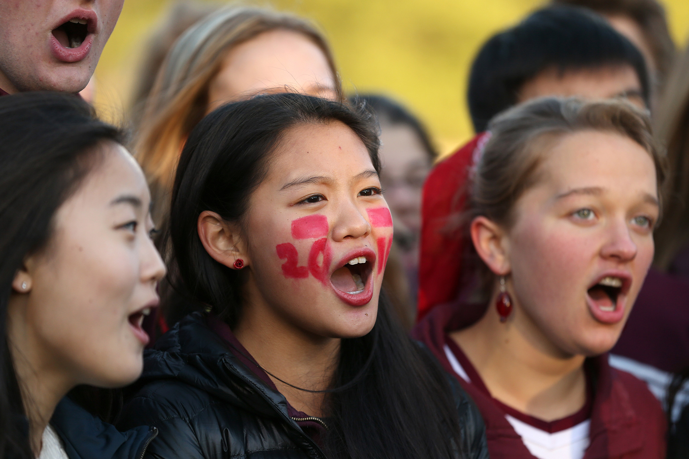 Phillips Exeter students sing the national anthem before a football game.