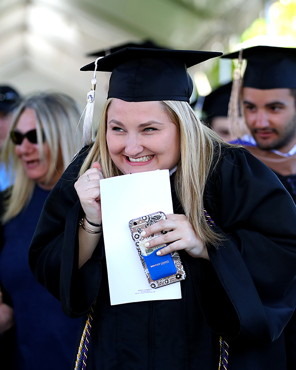 A Bentley Univ.  graduate shows her joy while entering for  graduation services.