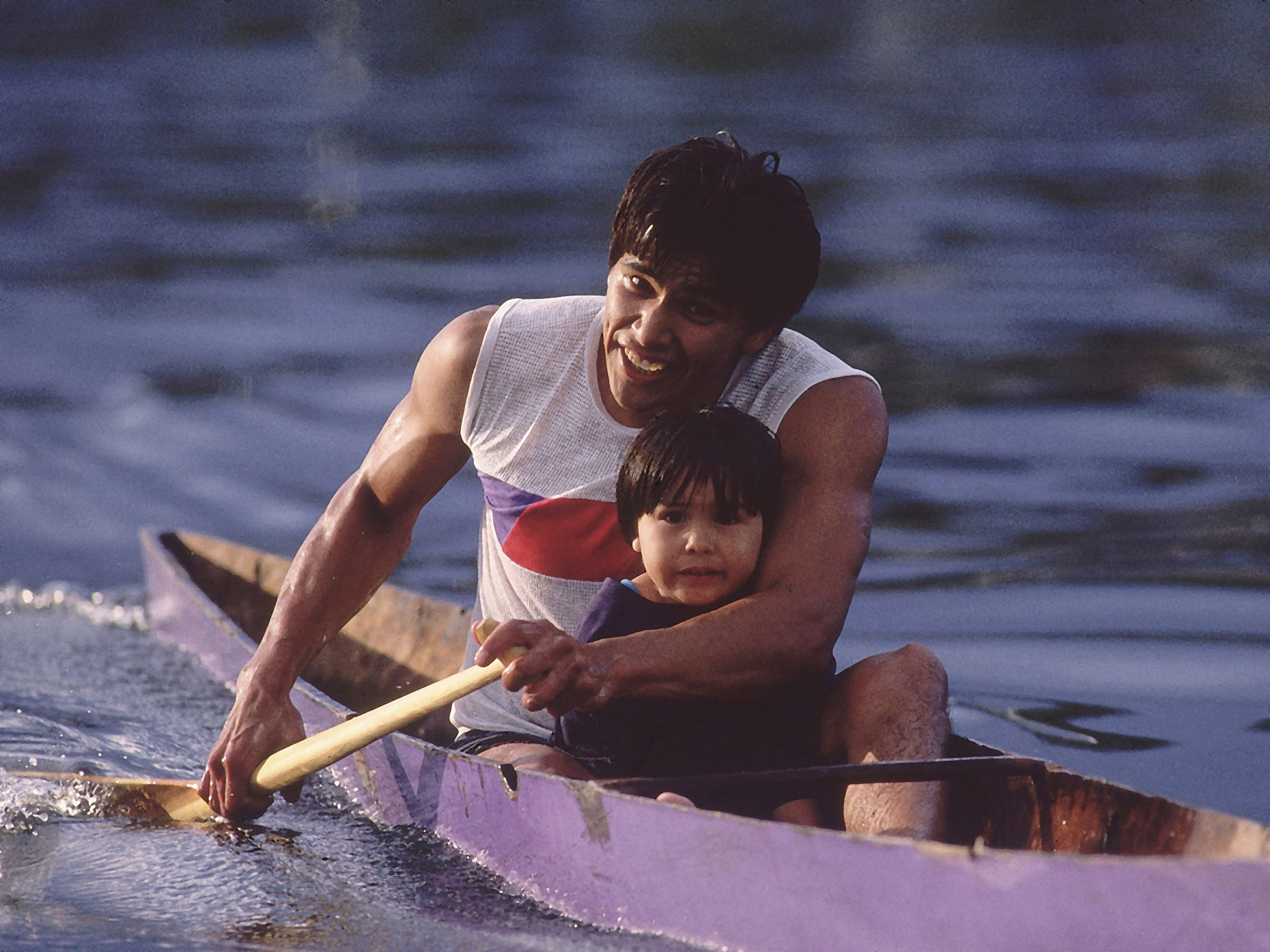 A father rows a canoe with his son on the Lummi Indian Reservation.