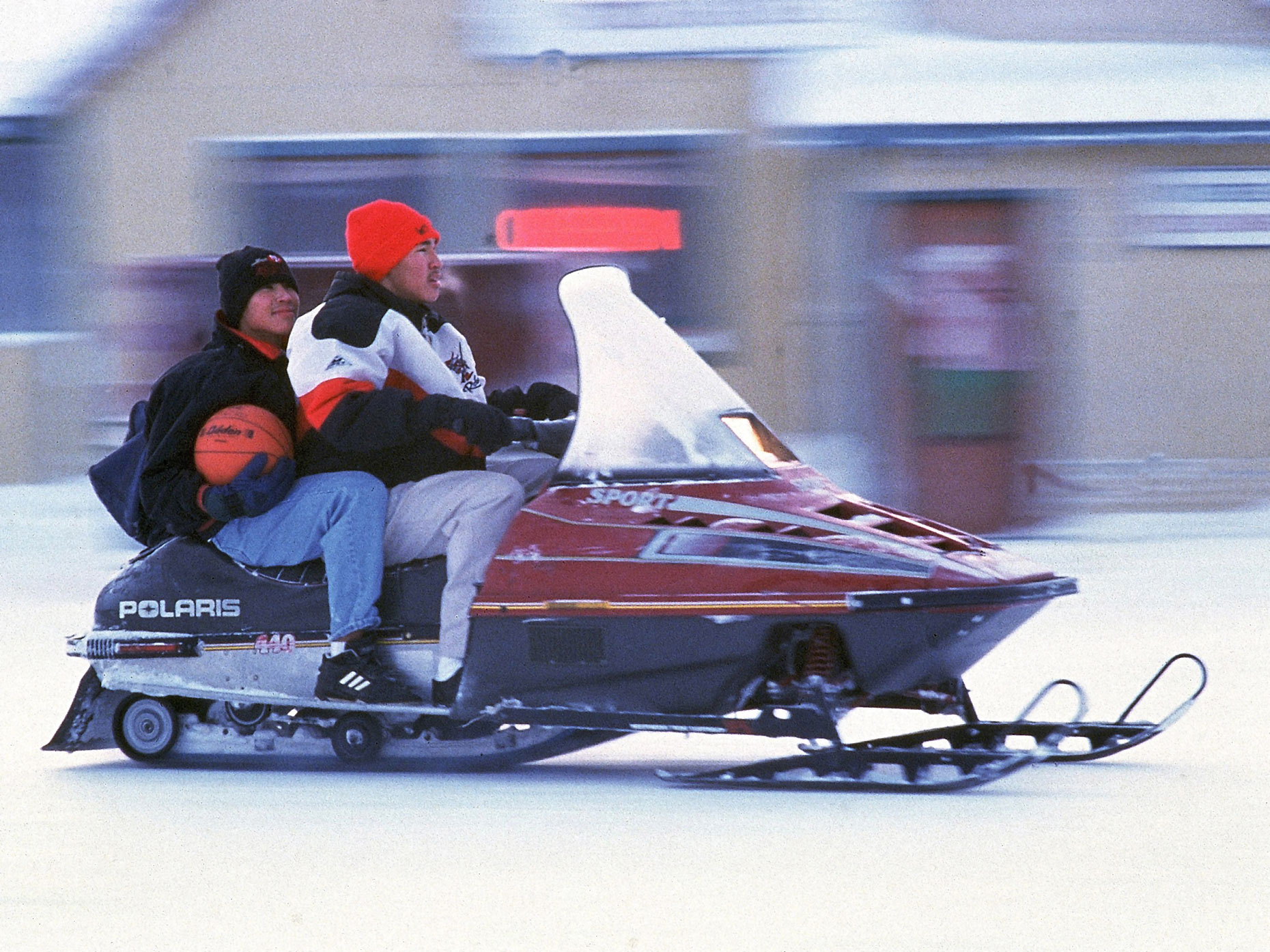 Basketball players head to practice on a snowmobile in Kotzebue, Alaska.