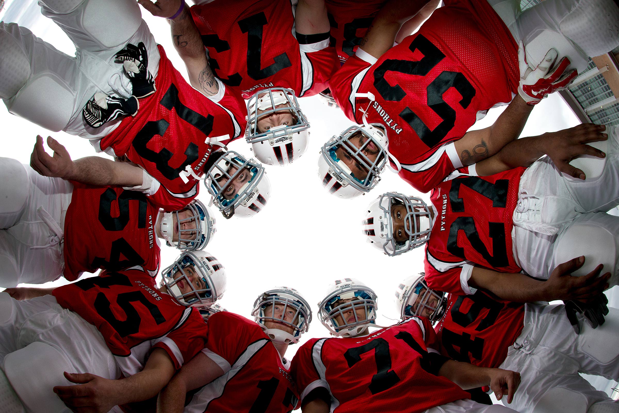 A low angle  view from inside the huddle showing the team from below.