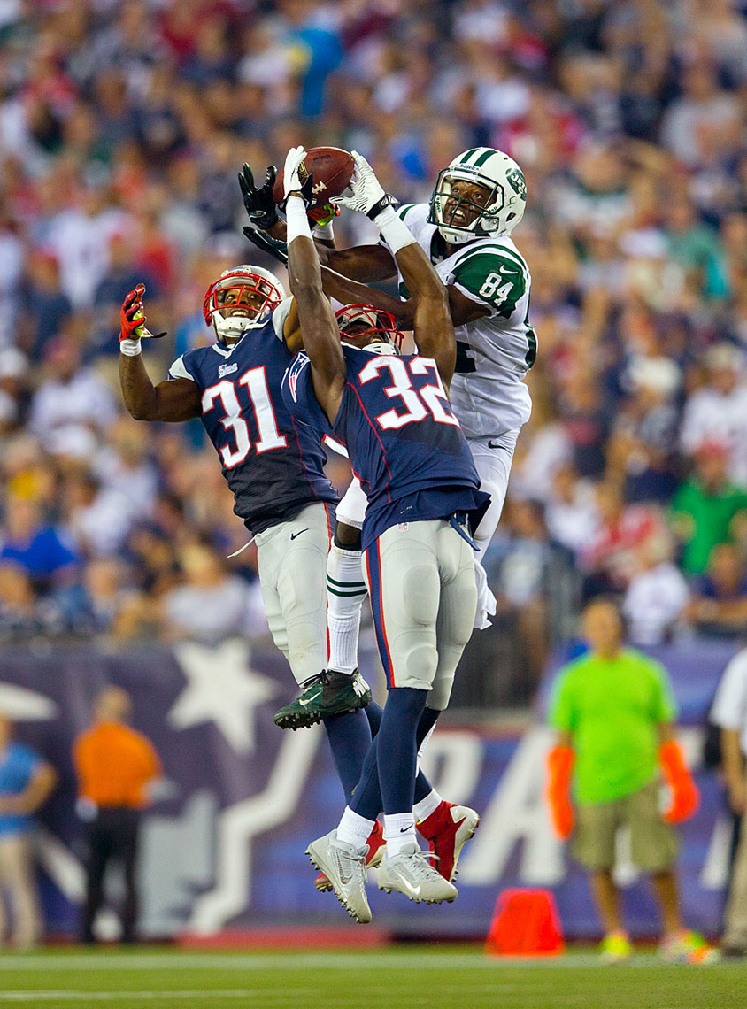 Jets receiver Stephen Hill battles New England defenders for a pass.
